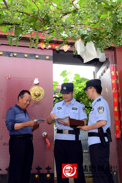 6月18日，枣庄市公安局山亭分局北庄派出所民辅警向北庄镇洪门村村民王光忠发放宣传资料，面对面宣讲反电诈常识。.jpg